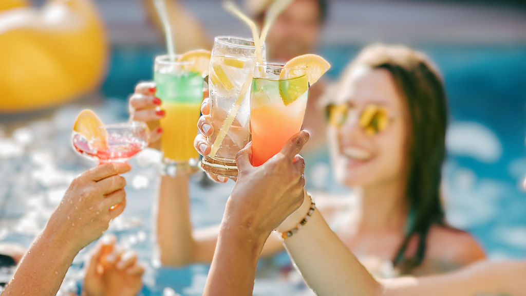 Pool party friends raise their colorful mocktails in salute of summer!